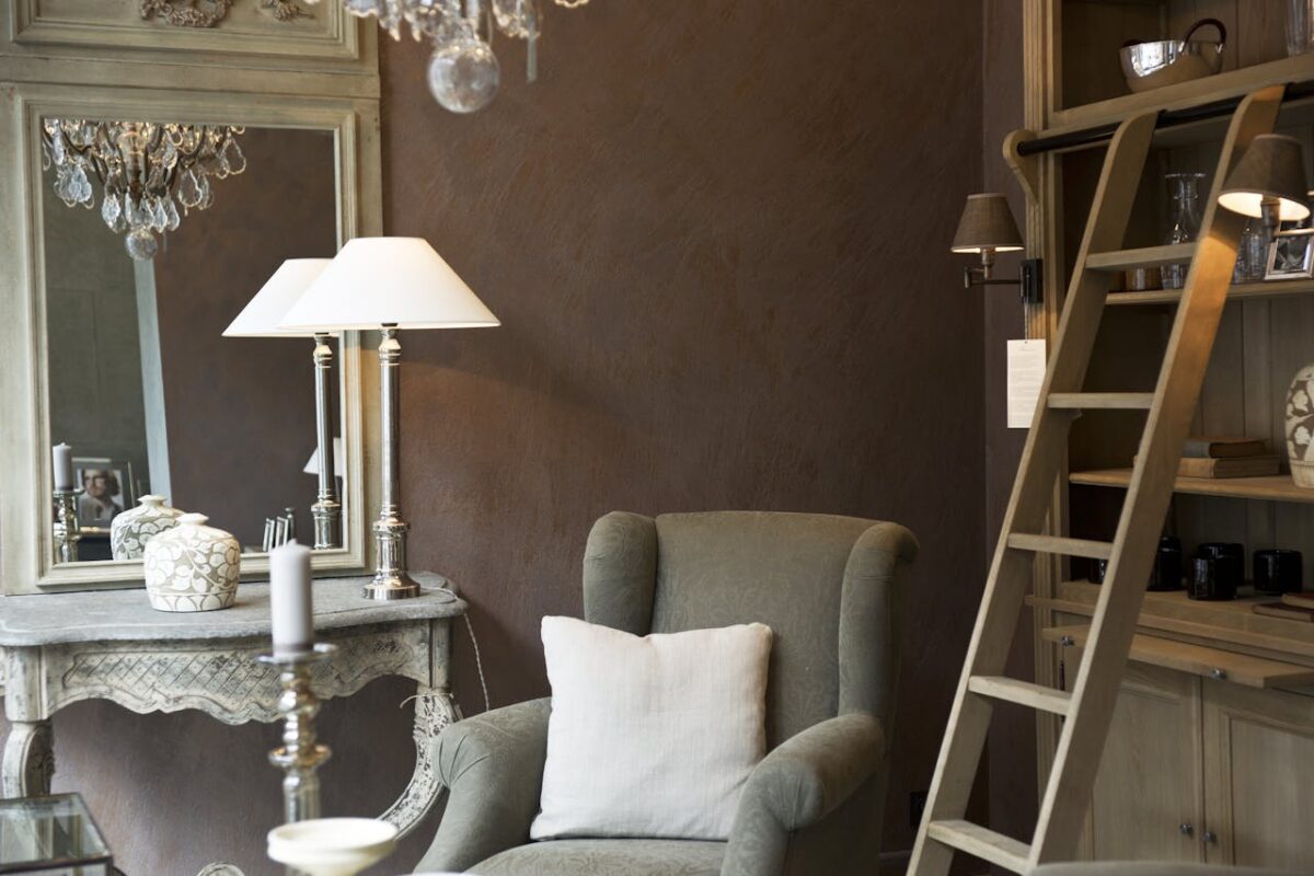 Chic interior featuring an armchair, vintage furniture, and decorative lighting.